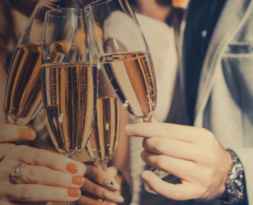 Freunde stoßen mit Gläsern voll Cava an